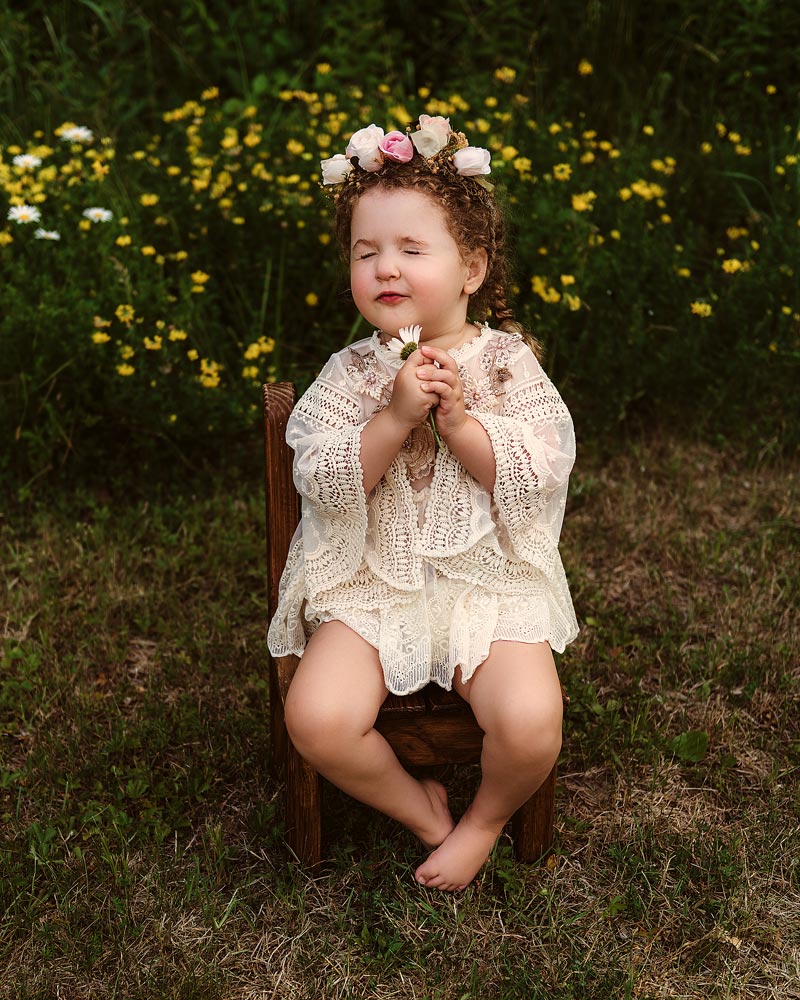 Londonderry Child photographer smelling flower wearing boho dress